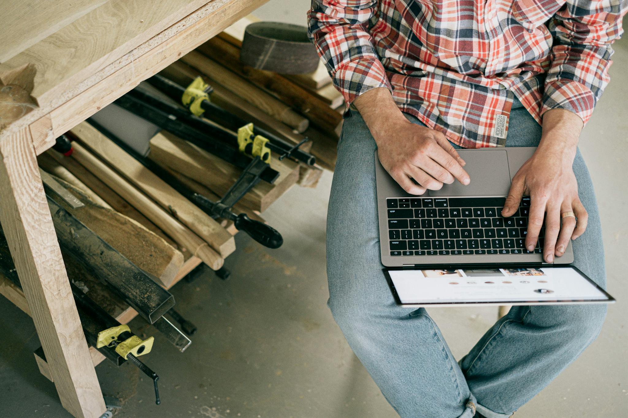 A man holds a laptop on his lap.