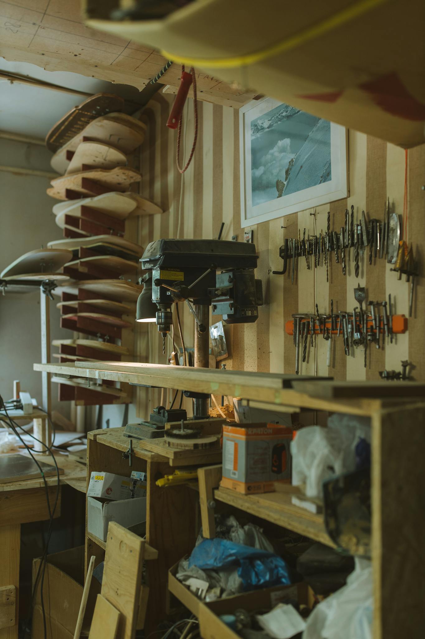 A wall full of tools featuring a drill press in the center.
